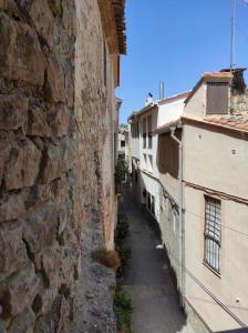 une allée entre deux bâtiments avec un mur en pierre dans l'établissement Casa el Recreo, à Jérica