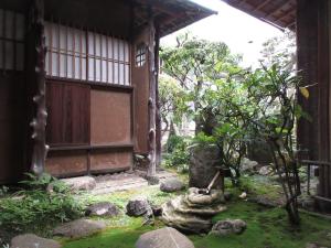 un exterior de un edificio con una puerta y un jardín en 蔵の宿　櫻林亭, en Miwa