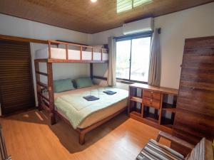 Jamburae Lodge في Lagudri: غرفة نوم مع سريرين بطابقين ومكتب