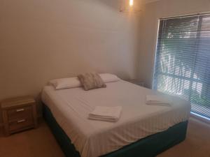 1 dormitorio con 1 cama con toallas en Mildura Holiday Homes - 15th Street, en Mildura