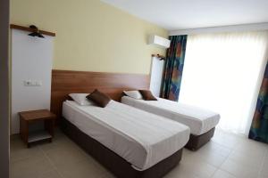 アンタルヤにあるKALİYE ASPENDOS HOTELのベッド2台と窓が備わるホテルルームです。