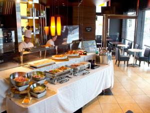 a buffet line in a restaurant with people preparing food at Hotel Hillarys in Osaka
