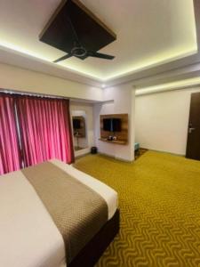 a hotel room with a bed and a flat screen tv at VOVO HOTELS in Yelahanka