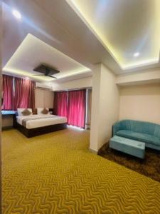 um quarto amplo com 2 camas e um sofá em VOVO HOTELS em Yelahanka
