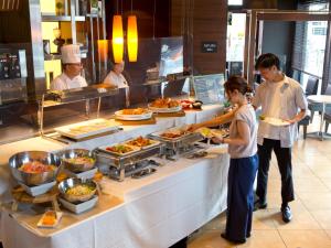 a group of people preparing food in a restaurant kitchen at Hotel Hillarys in Osaka