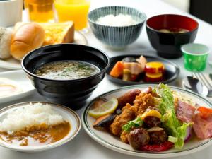 a table with plates of food and bowls of food at Hotel Hillarys in Osaka