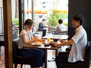 a man and woman sitting at a table eating food at Hotel Hillarys in Osaka