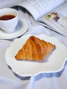 een croissant op een bord naast een kopje koffie bij Sheraton Shanghai Jiading Hotel in Jiading