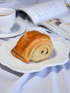 a pastry on a white plate next to a cup of coffee at Sheraton Shanghai Jiading Hotel in Jiading