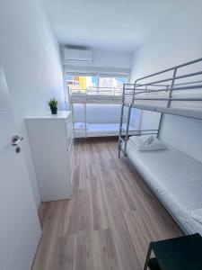 a dorm room with bunk beds and a wooden floor at Los Alcores 2.0 in Torremolinos