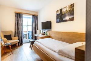 um quarto de hotel com uma cama e uma cadeira em Hotel-Garni Schernthaner em Sankt Gilgen