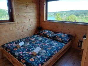 una cama en la esquina de una cabaña en Przystanek Jawory, en Wołkowyja