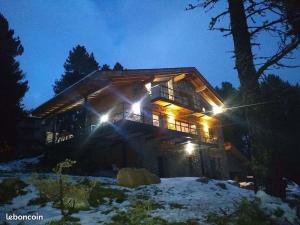 a log cabin lit up at night with lights at Chalet Husky , Familliale, Calme, Spatieux in Bolquere Pyrenees 2000