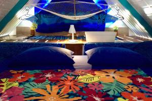 een slaapkamer met 2 bedden en een kleurrijk tapijt bij L'Auberge de Tahiti Iti - Beach hostel in Afaahiti