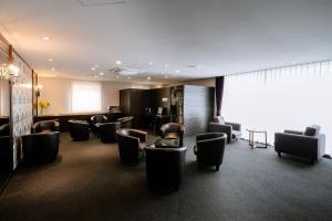 a waiting room with couches and chairs in a building at Hotel Hillarys in Osaka