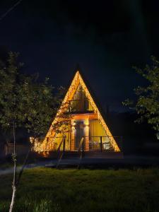 una casa en el árbol con luces encendidas por la noche en B&B Cottage in Mestia en Mestia
