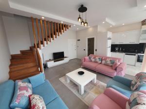 a living room with two couches and a table at Dreamy luxury two-bedroom penthouse apartment with special forest, mountain and sea views in Alanya