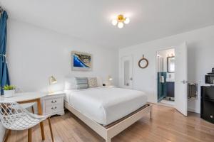 een slaapkamer met een bed, een bureau en een stoel bij The Ocean Resort Inn in Montauk