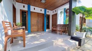 ganek domu z drewnianymi drzwiami w obiekcie Nusawiru Guest House w mieście Pangandaran