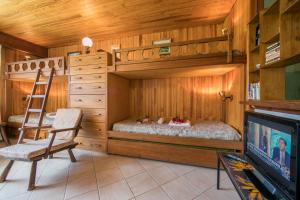 Pokój z łóżkiem piętrowym, krzesłem i telewizorem w obiekcie Résidence Grands Montets 110 - Happy Rentals w Chamonix-Mont-Blanc