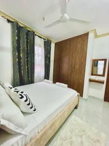 a bedroom with a large bed and a window at Ngoki’s comfort apartment in Mombasa