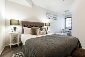 a bedroom with a large bed and a chair at VAQUAY Glamptons In Docklands in Melbourne +34 photos