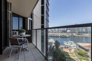 a balcony with a table and a view of the water at VAQUAY Glamptons In Docklands in Melbourne