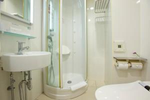 a bathroom with a sink and a shower at Hotel Hillarys in Osaka
