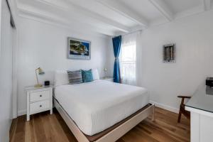 a white bedroom with a bed and a window at The Ocean Resort Inn in Montauk