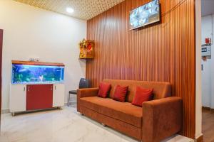 ein Wohnzimmer mit einem Sofa und einem Aquarium in der Unterkunft FabHotel Atharva Executive in Pune