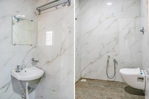 La salle de bains blanche est pourvue d'un lavabo et de toilettes. dans l'établissement FabHotel Atharva Executive, à Pune