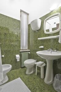 フォリーニョにあるHotel Valentini Innのバスルーム(洗面台、トイレ、鏡付)