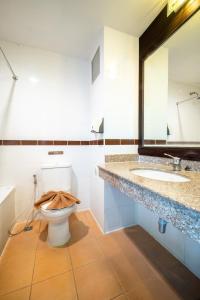 y baño con aseo, 2 lavabos y espejo. en J A Plus Hotel en Pattaya Central