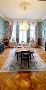 une salle à manger avec une table, des chaises et un lustre dans l'établissement Stadtvilla Rostock - 160 qm Apartment zentrumsnah, à Rostock