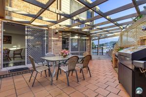 a dining room with a table and chairs on a patio at Aircabin - Woy Woy - Water Front - 6 Beds Lux Home in Daleys Point