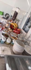 a kitchen counter with a bunch of dishes and bananas at Hotel Villa Ruci in Ksamil