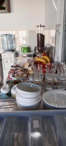 a kitchen counter with plates and bowls and glasses at Hotel Villa Ruci in Ksamil