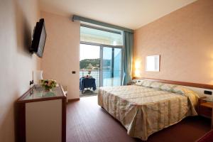 a hotel room with a bed and a large window at Hotel San Terenzo in Lerici