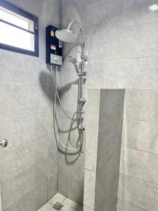 a shower with a shower head in a bathroom at อาร์.เจ.แมนชั่น in Chon Buri