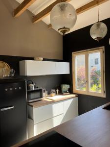 a kitchen with white cabinets and a black refrigerator at Magnifique! Idéal! in Grosseto-Prugna +12 photos
