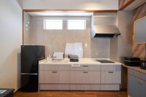 a kitchen with a sink and a black refrigerator at S-villa nasu Green hills in Nasu