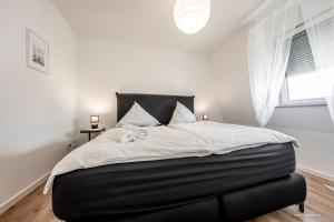 Artdesign - 8 Pers - nähe Speyer Mannheim Heidelberg في هوكنهايم: غرفة نوم بسرير كبير مع شراشف بيضاء