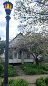 una luz de la calle frente a una casa con un árbol florido en Pinkston Gardens en Saint Paul