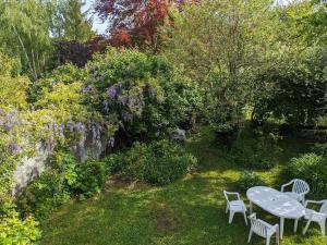 einen Tisch und Stühle in einem Garten mit Blumen in der Unterkunft LES VOLETS BLEUS in Metz