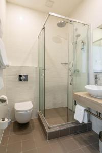ein Bad mit einer Dusche, einem WC und einem Waschbecken in der Unterkunft City Hotels Rūdninkai in Vilnius