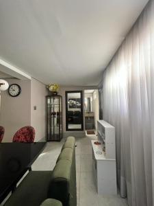 a living room with a couch and a table and a clock at Casa Santos Piscina e Praia in Santos