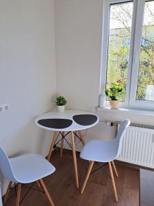 two tables and two chairs in a room with a window at Lauku Str.Apartment in Liepāja