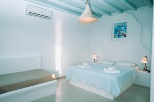 صوفياز بانغلوز ميكونوس في مدينة ميكونوس: غرفة نوم بيضاء مع سرير وحوض استحمام