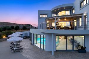 a large house with a swimming pool and umbrellas at Rhodes Kallithea Villa - Zafira Private Pool Gem in Kallithea Rhodes