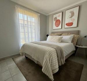 a bedroom with a bed and a window at Lux Homes Property's in Johannesburg